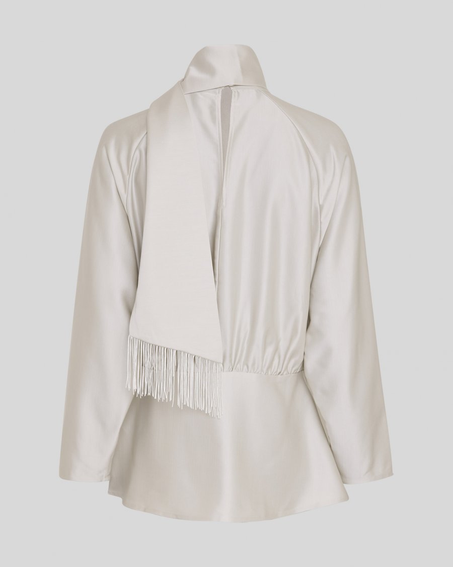 An off-white satin jacket with a high collar, long sleeves, and a fringed detail at the waist, shown from the back against a light gray background.