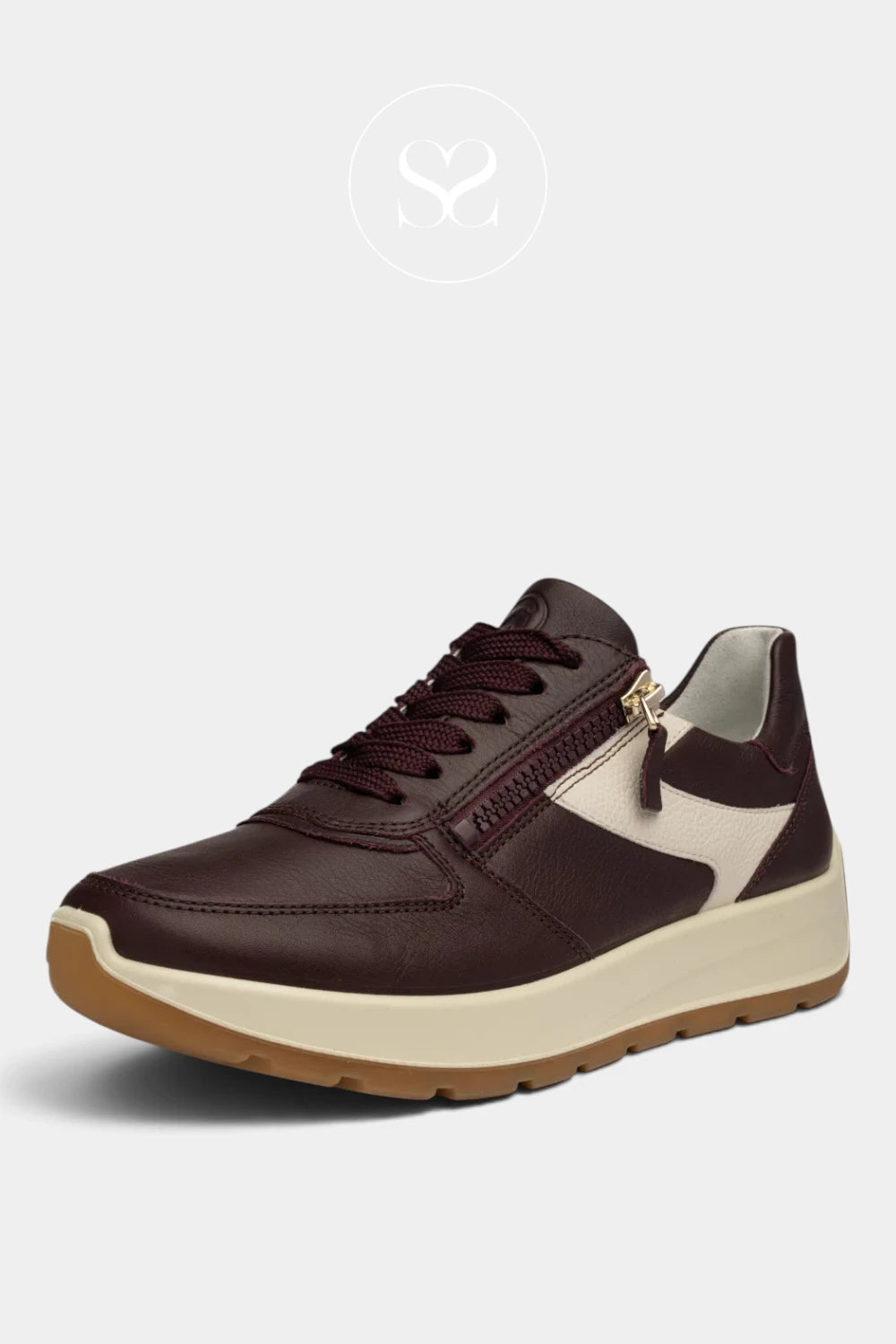 A women's low-top sneaker in dark burgundy brown leather with cream-colored side panels and a cream midsole, featuring a brown gum outsole and a gold-tone zipper pull.
