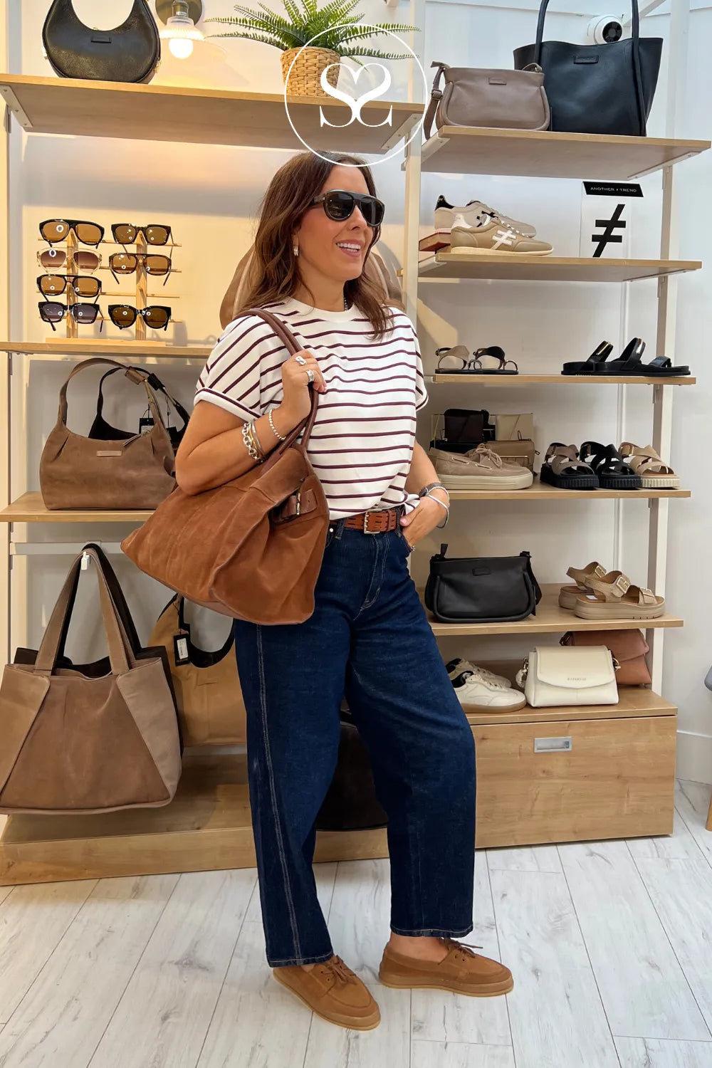 Woman wearing tamaris slip on deck shoes in tan suede with matching depeche large handbag