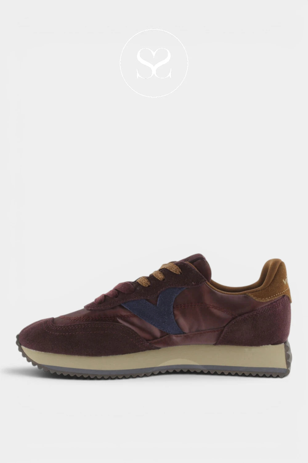 A low-top sneaker in burgundy suede and leather with a navy blue side stripe, brown laces, a brown heel tab, and a beige midsole, shown against a light gray background.