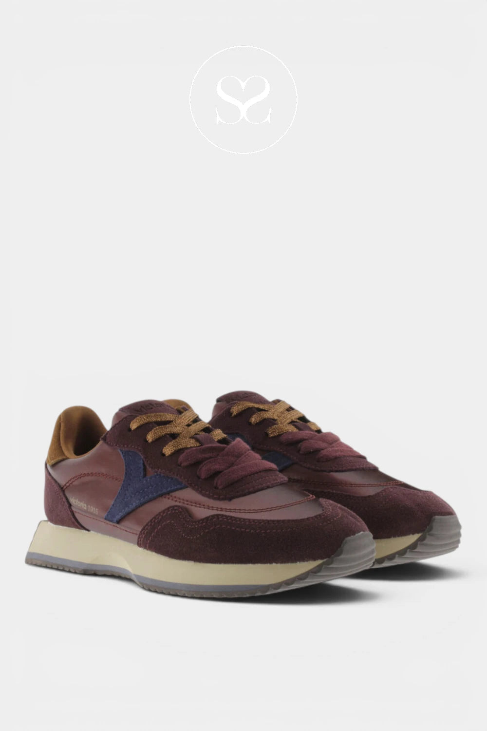 A pair of low-top sneakers in burgundy suede and mesh with a navy blue side logo, tan laces, and a cream midsole, shown against a light gray background.
