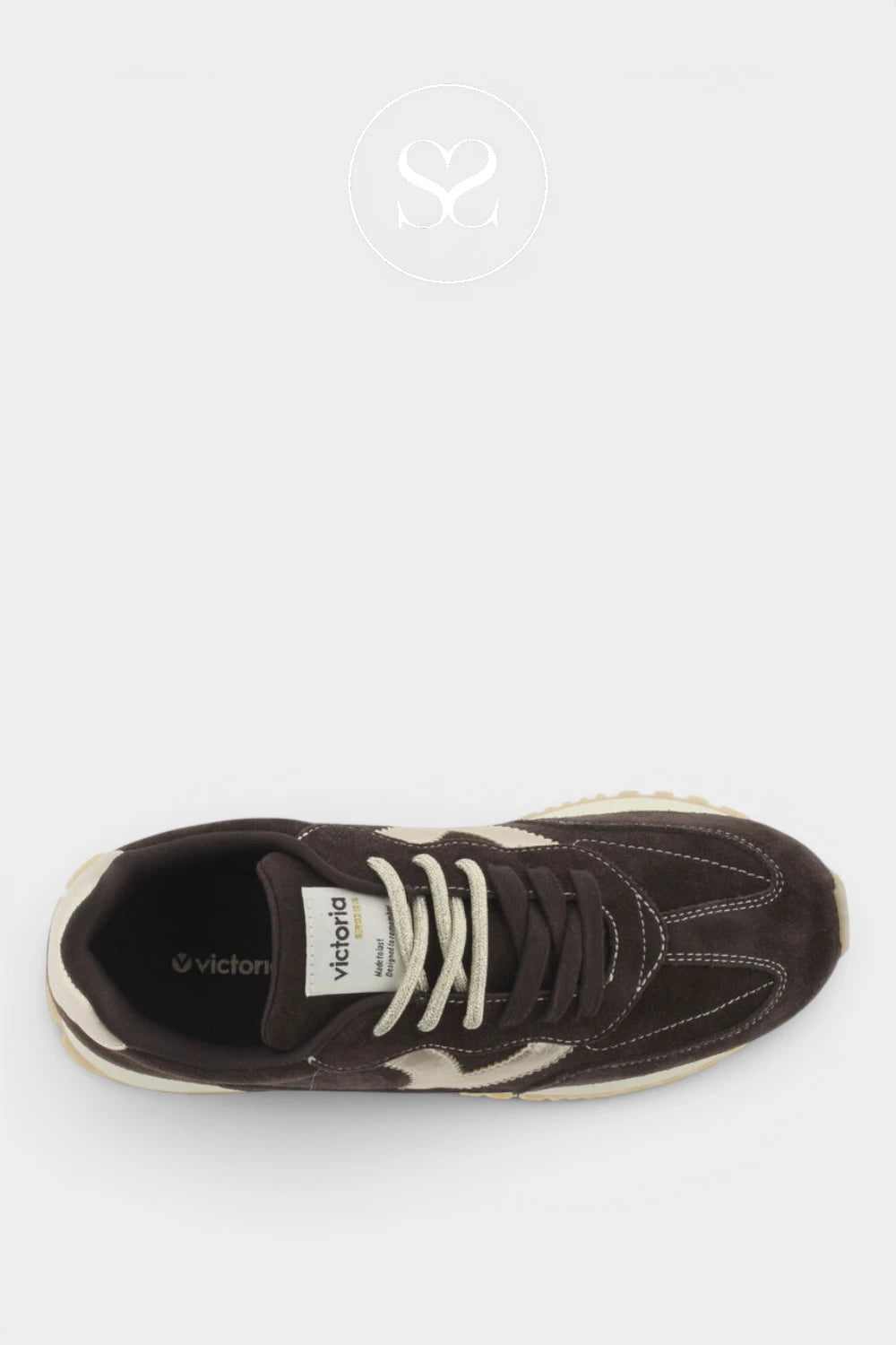 A dark brown suede and leather sneaker with cream laces and a cream midsole accent, shown from a top-down view on a light gray background.