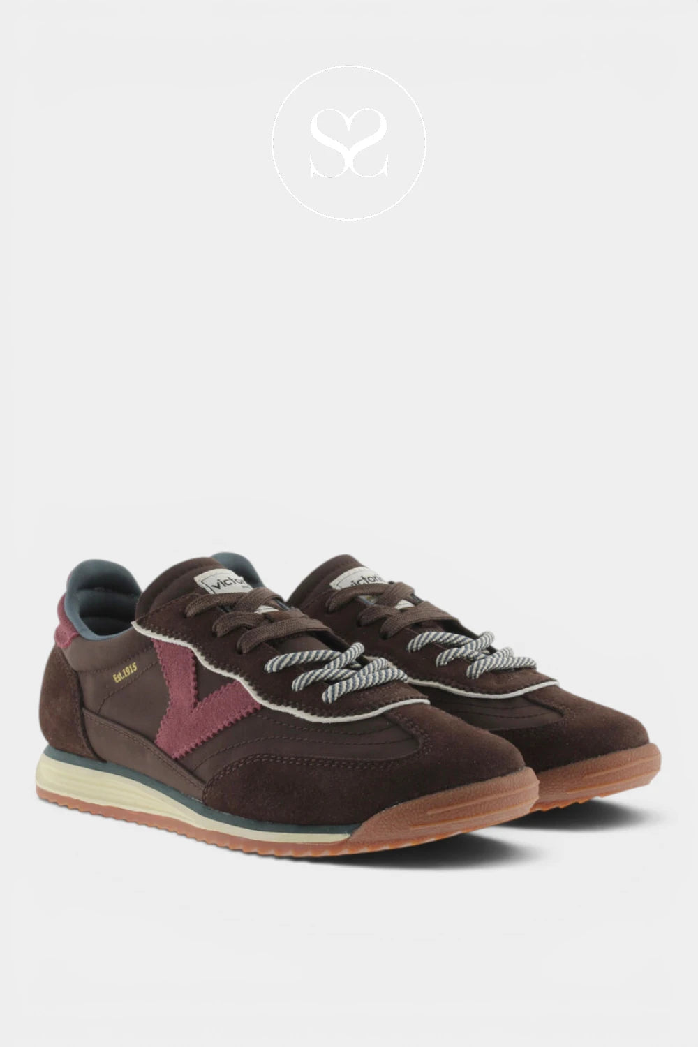 A pair of vintage-style low-top sneakers in dark brown suede and leather, featuring a dusty pink side stripe, white rope laces, a cream midsole, and a gum outsole, shown against a light gray background.