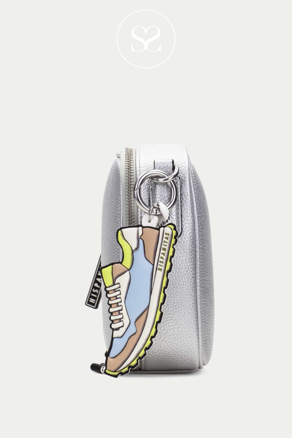 HISPANITAS silver crossbody bag with crossbody strap and one main zip pocket. Colourful trainer keyring. Metallic small leather bag