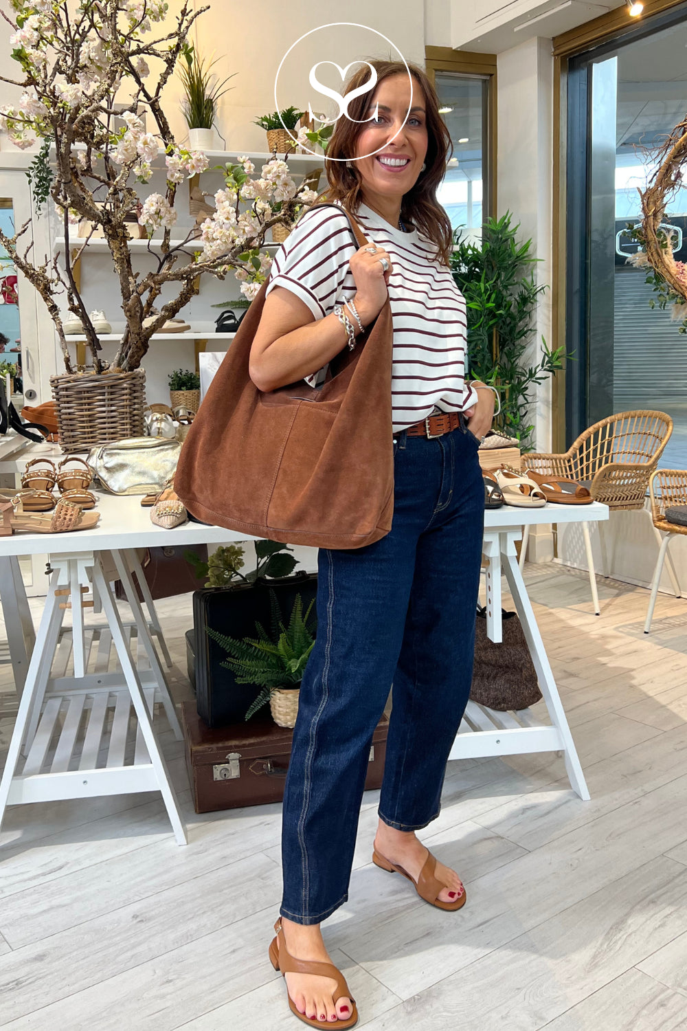 woman wearing comfortable flat tan sandals from Angel alarcon paired with slouch tan suede shopper bag from Depeche