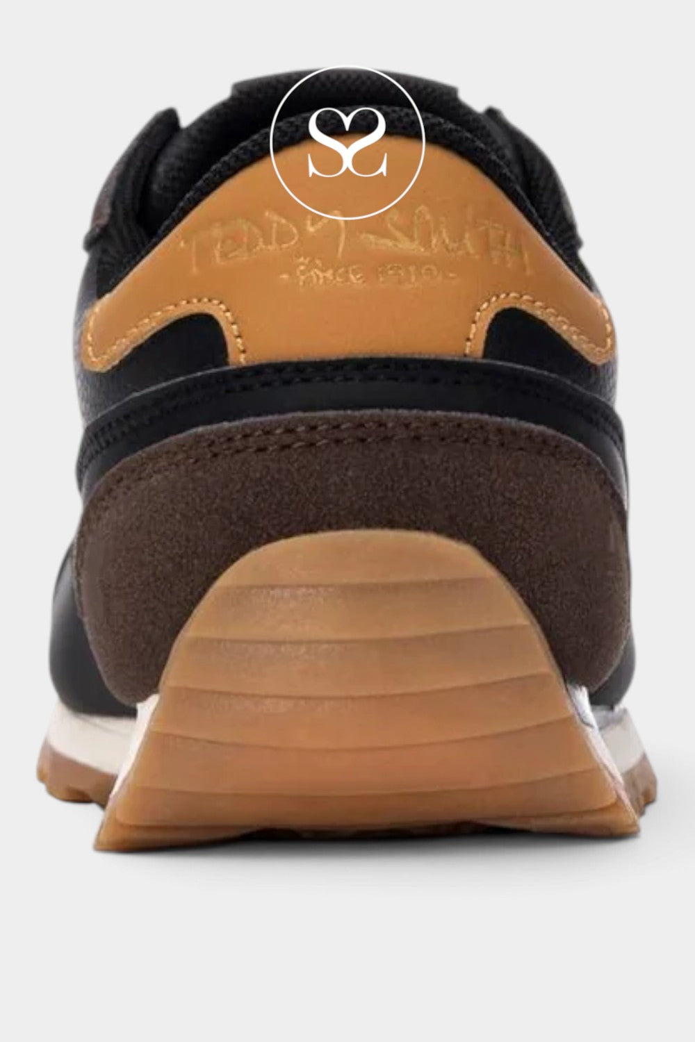 Close-up rear view of a low-top sneaker in black, brown, and tan suede, with a tan rubber outsole and a white midsole.