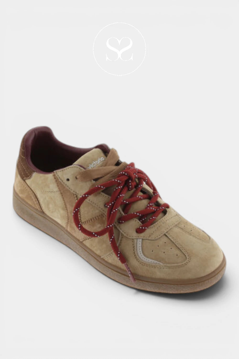 A low-top suede sneaker in beige with burgundy laces and a burgundy inner lining, shown on a light gray background.