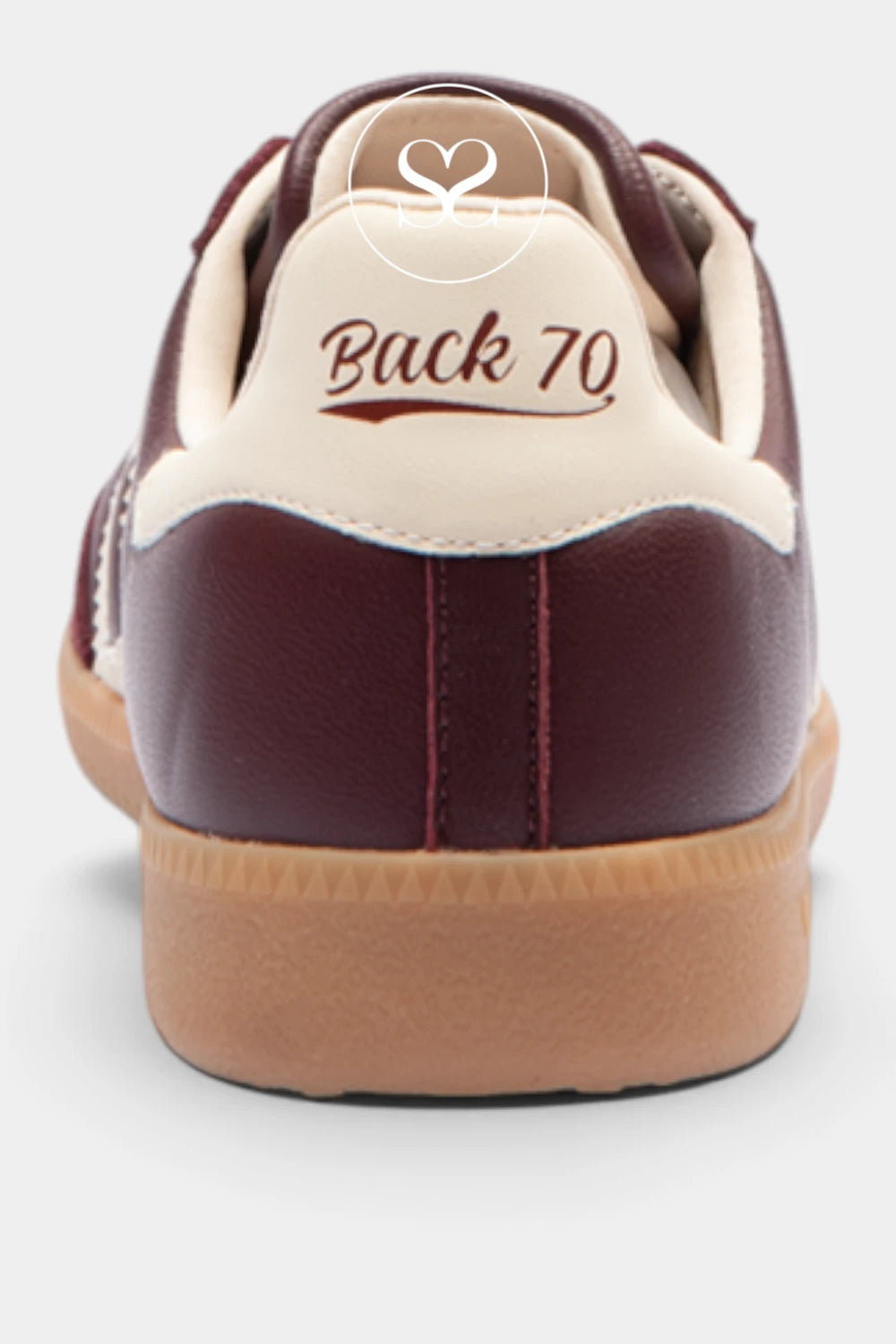 A close-up rear view of a low-top sneaker with burgundy leather panels, a cream collar, and a tan gum sole. The heel tab is cream with the text 'Back 70' printed in burgundy, and a small white heart logo is visible above it.