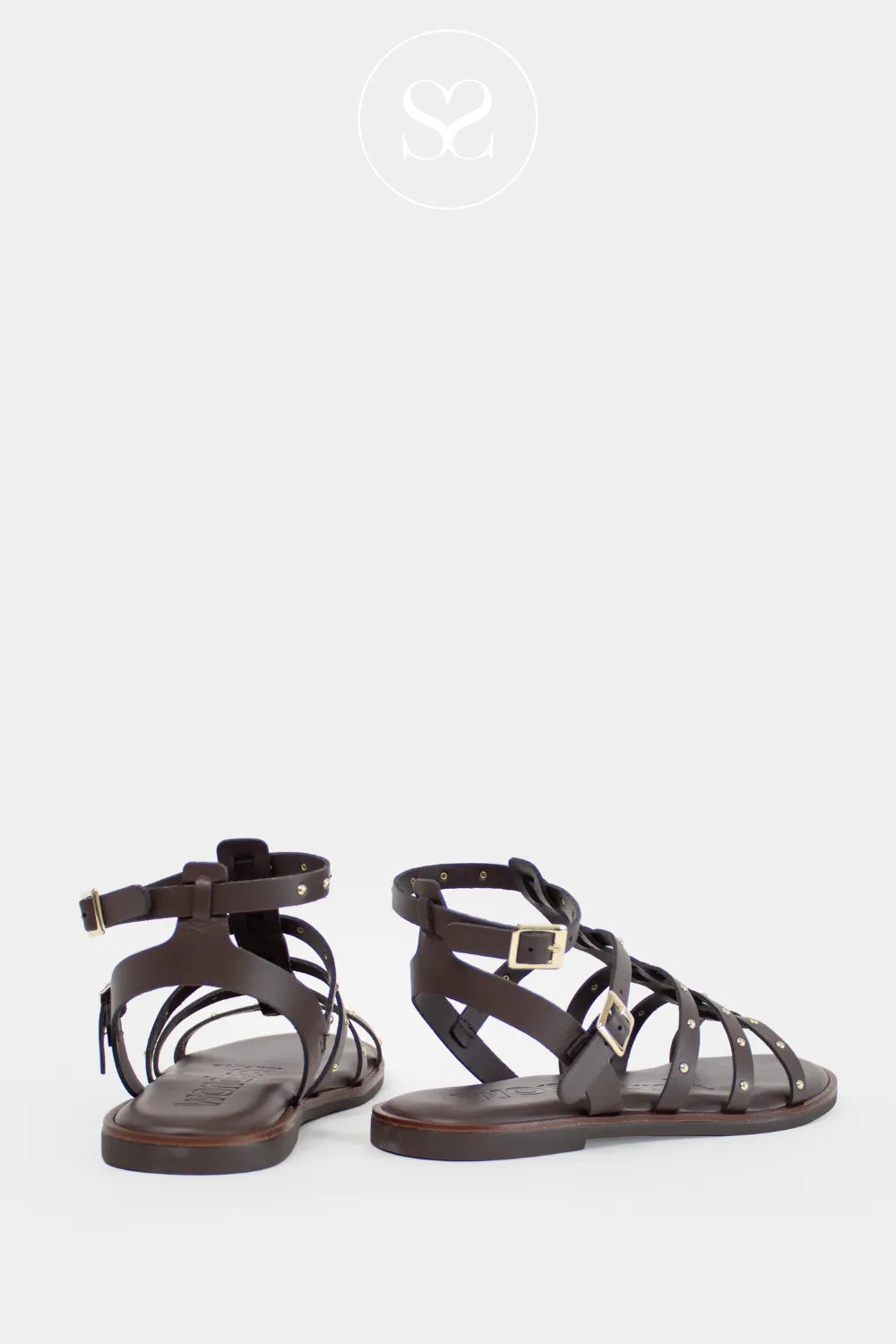 Brown leather flat sandals with two adjustable ankle straps.