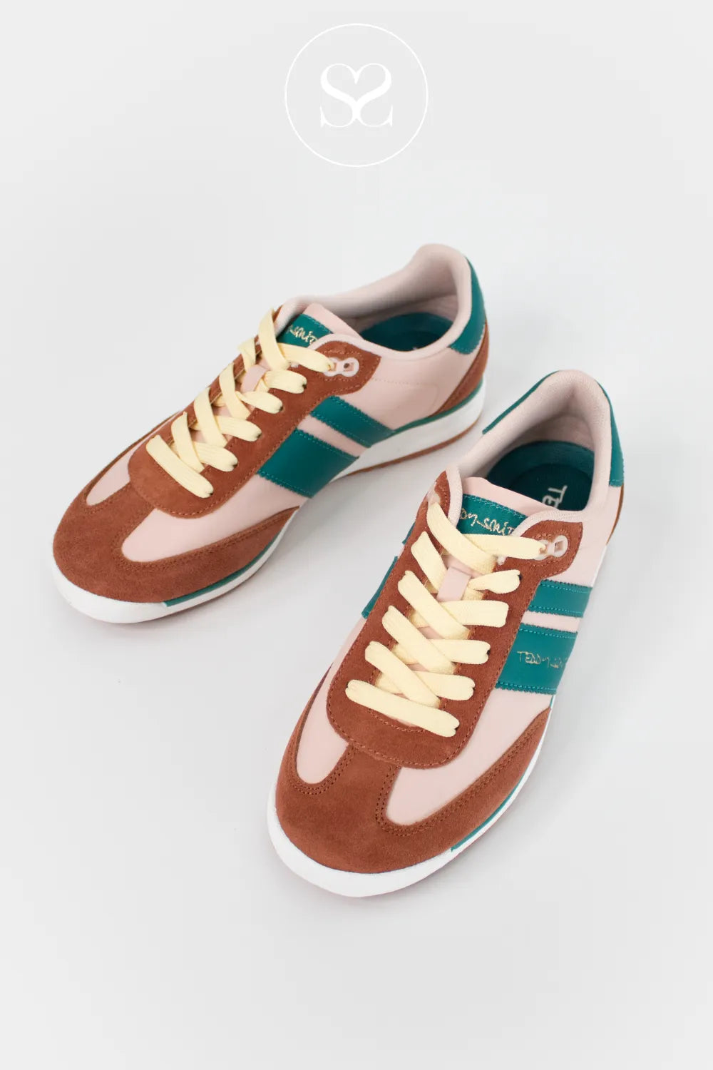 Pair of brown and pink sneakers with green stripes on a white background