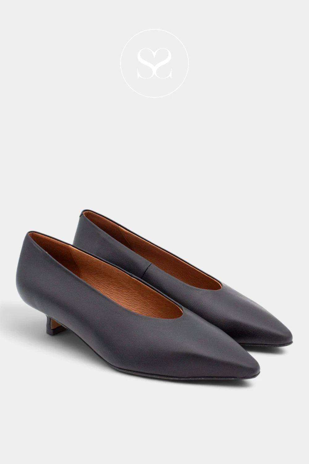 A pair of dark charcoal gray pointed-toe flats with low kitten heels and a contrasting brown leather interior, shown on a light gray background with a faint brand logo at the top.