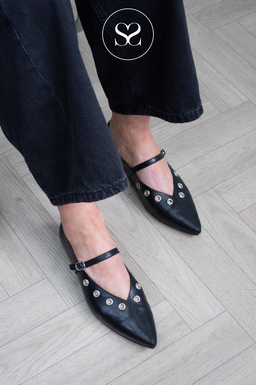 Wonders black mary jane flats with pointed toe and eyelet detail worn with black barrel jeans in Ireland