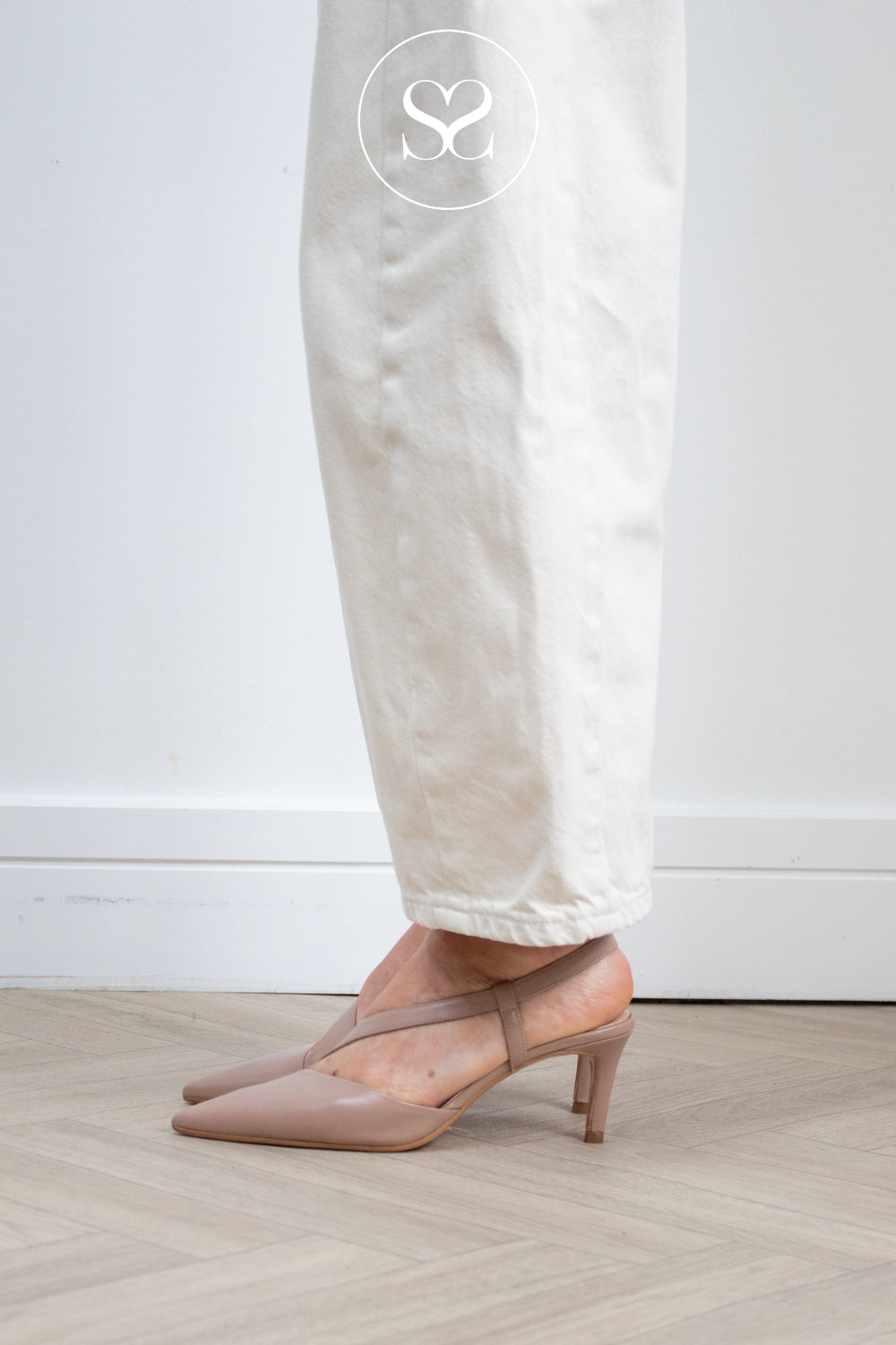 Woman wearing Lodi Naltom Taupe/Nude pointed toe kitten heels with supportive cross strap