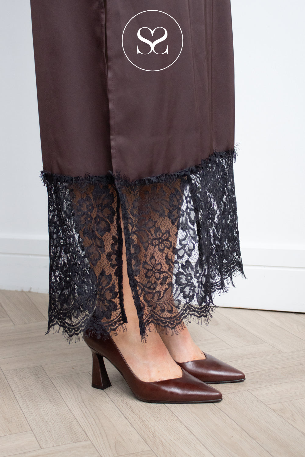 LODI Ralina court shoes in brown leather, showing the flared sculptural heel and pointed toe from a side-angle view.