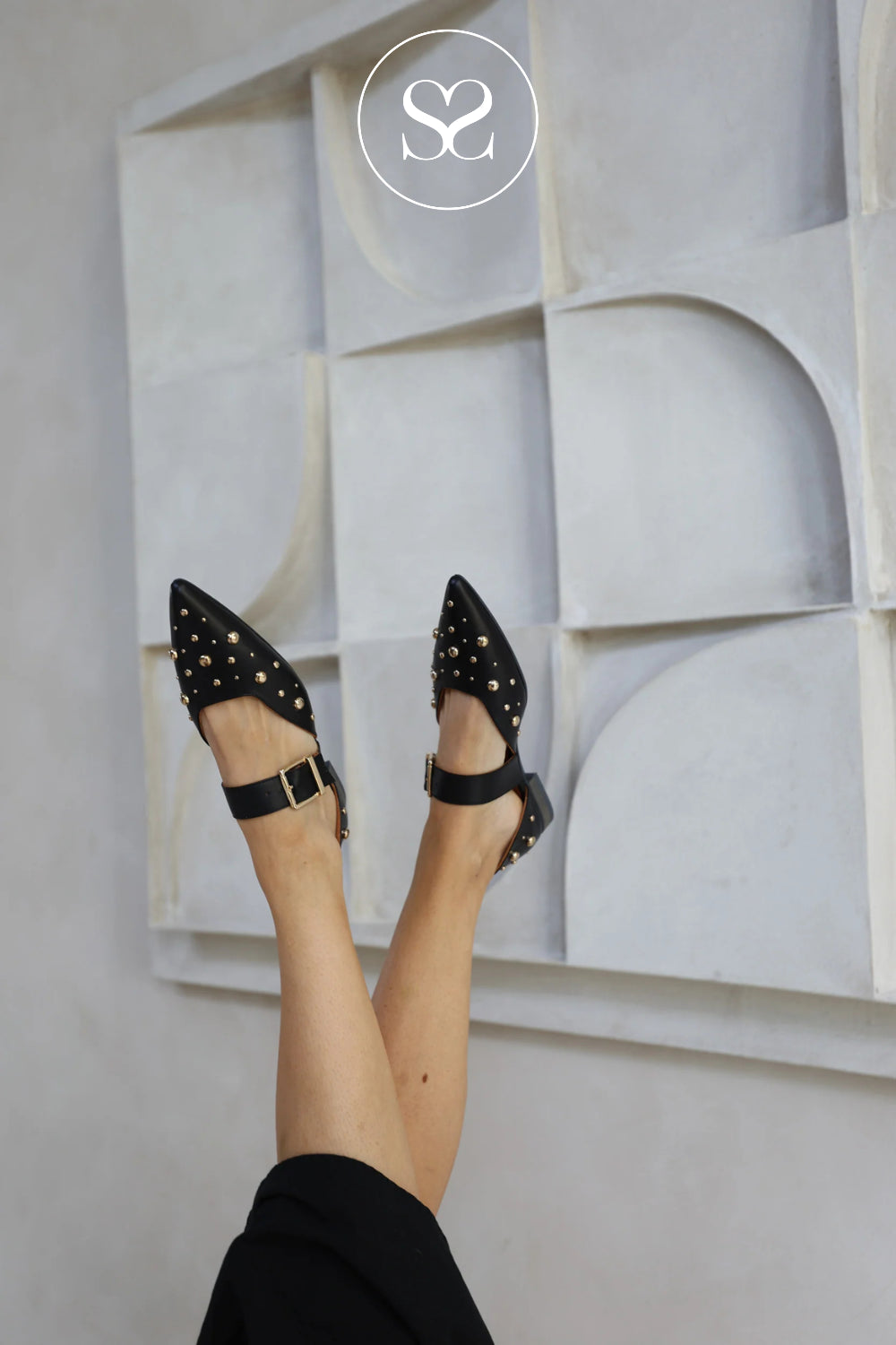 woman wearing black Mary-Jane flats with gold studs from Babouche