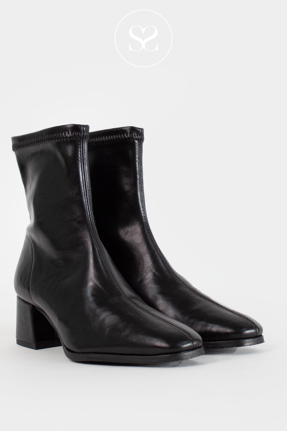 A pair of black leather ankle boots with a block heel and square toe, shown against a light gray background with a circular logo watermark at the top.