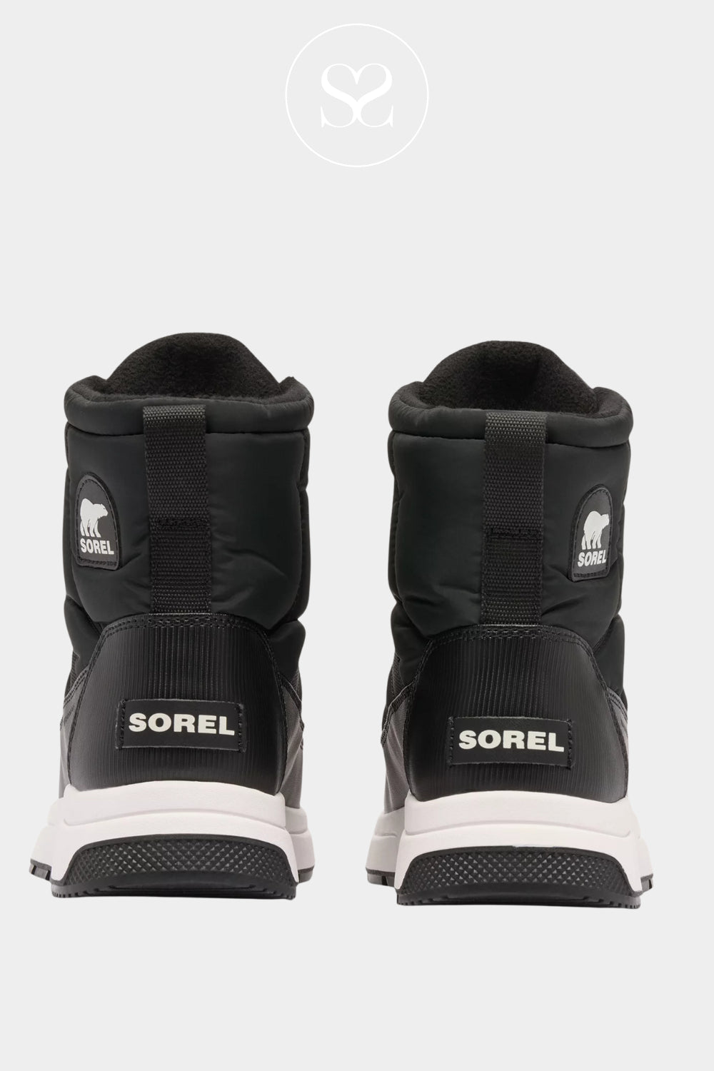 Black Sorel boots with white soles on a light grey background - Ireland