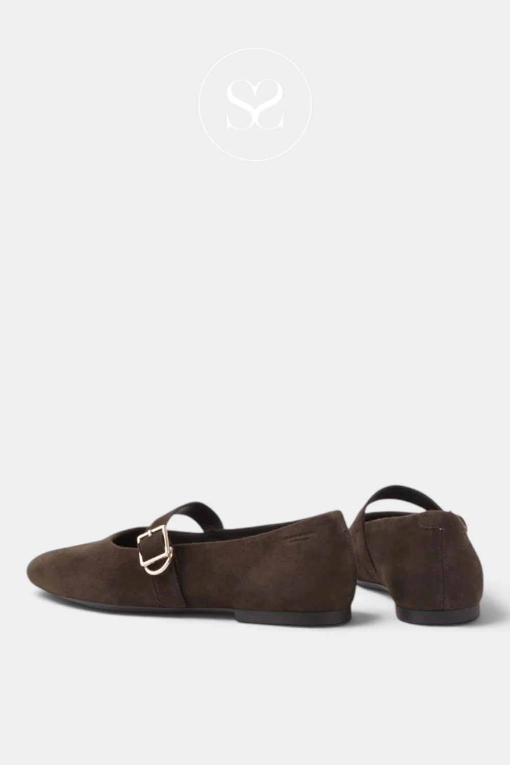 A pair of dark brown suede flat shoes with a single strap and a small gold buckle, shown from the side against a light gray background.