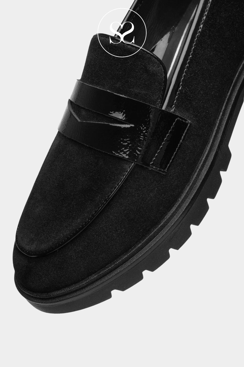 Women’s black flat shoes with a chunky sole, blending soft suede texture, glossy accents and timeless loafer styling.
