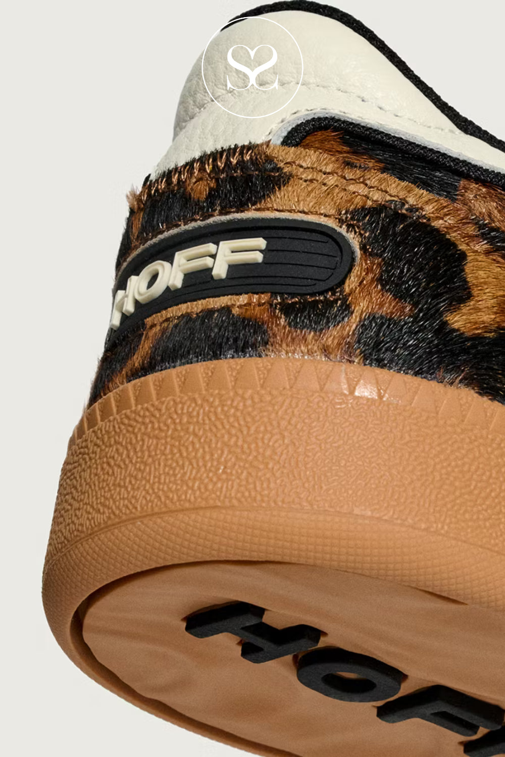 Close-up of a sneaker with leopard print and 'HOFF' branding on a light grey background