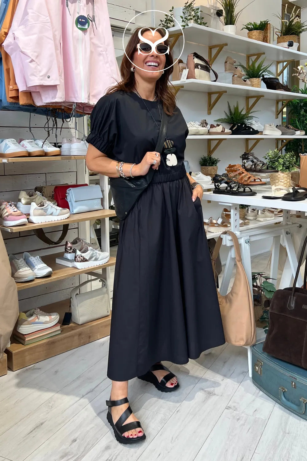 woman wearing black oh my sandala wedge walking sandals with supportive cross strap and cushioning