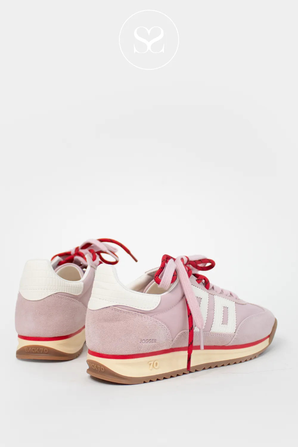 Trendy sneakers, retro style. Laced sneakers. Pink trainers with white heel cap and logo on the side