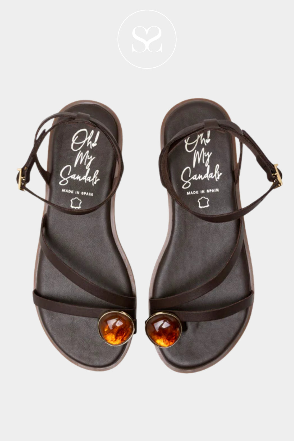 Pair of black sandals with brown straps and orange gemstones