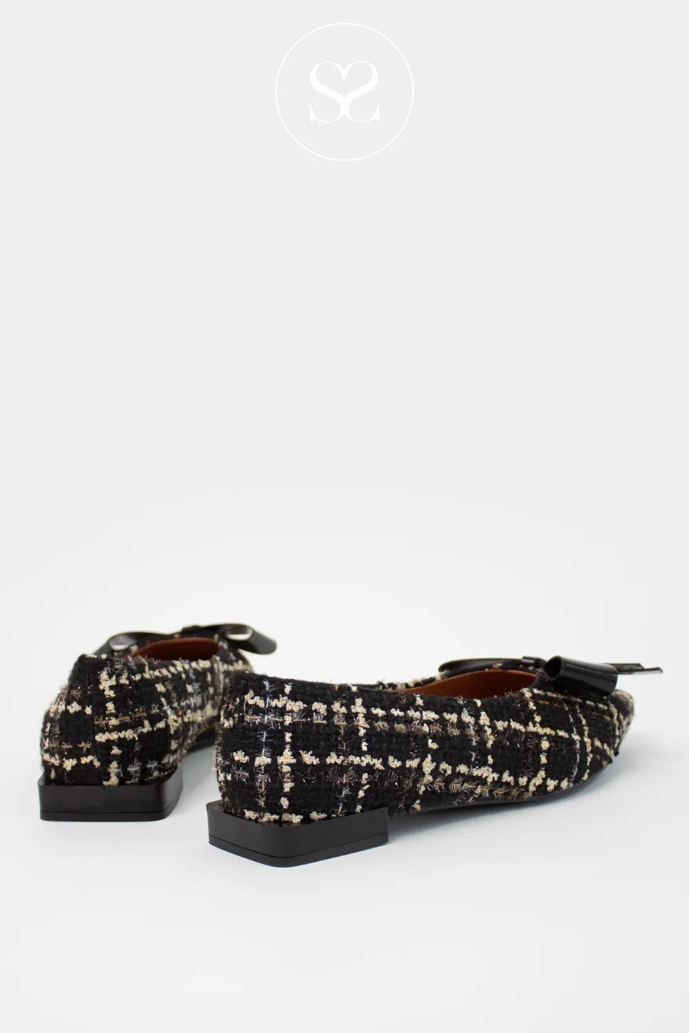 Pair of black and white checkered loafers on a white background