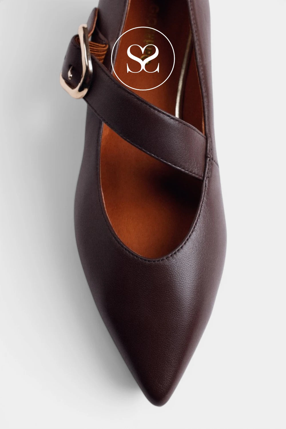 A dark brown leather pointed-toe pump with a Mary Jane strap and a gold-tone buckle, shown from a top-down angle on a light gray background.