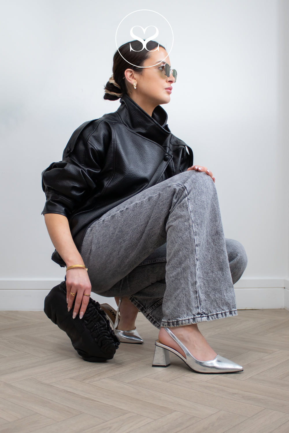 Model wearing edgy black outfit with silver metallick pointed toe sling back heels from Bianco