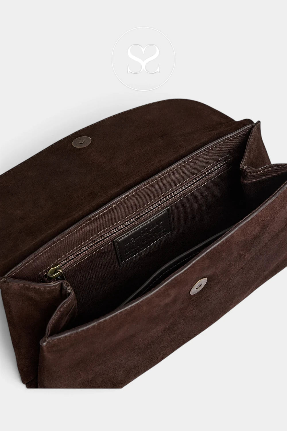 A close-up of a dark brown suede or faux-suede clutch bag shown open, revealing an interior zip pocket and snap-button closure on a light gray background.