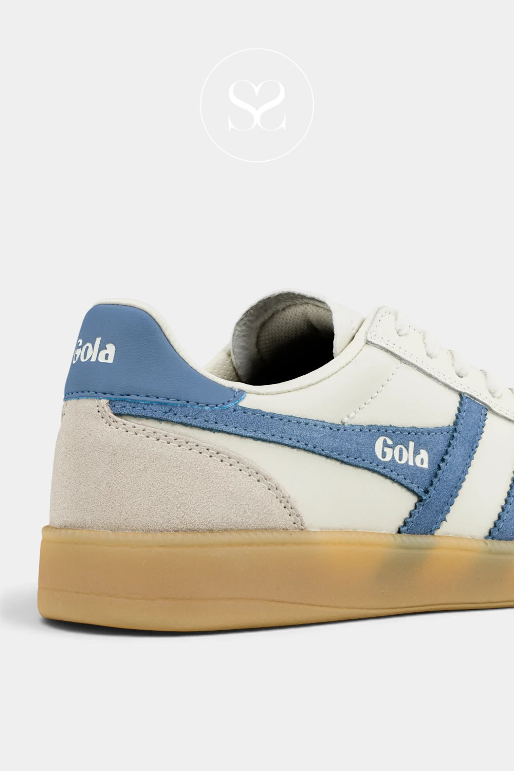 A close-up side view of a Gola brand low-top sneaker featuring off-white leather panels, light blue suede overlays, a light blue heel tab, and a translucent gum sole.