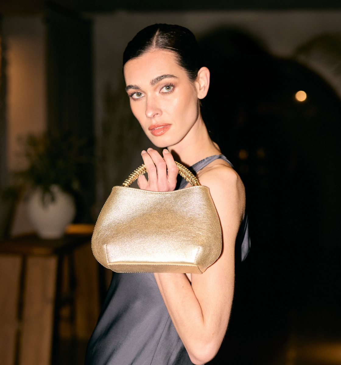 woman wearing gold clutch evening bag