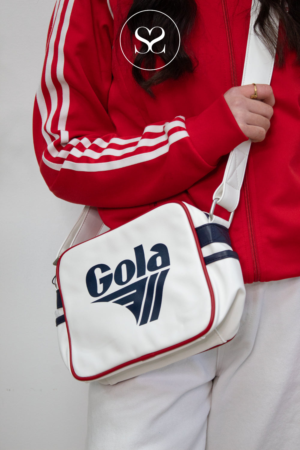 Person wearing gola redford bag in cream with navy and red accents
