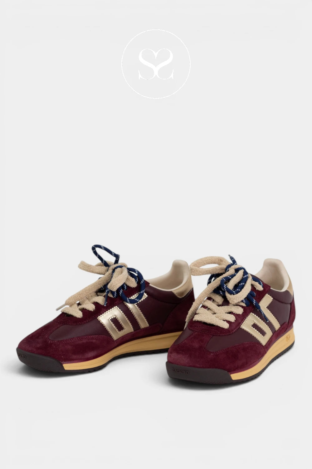 Wine suede trainers with cream laces and a set of blue laces. Black rubber toe cap and rubber sole.