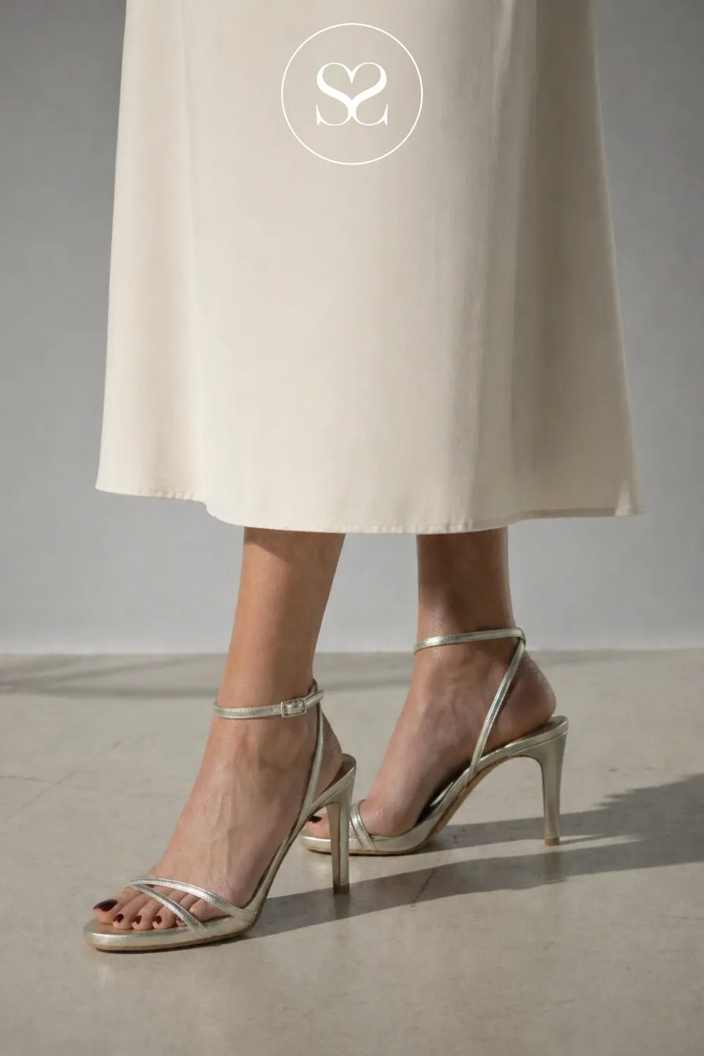 Woman wearing comfortable gold high heeled sandals from Lodi 