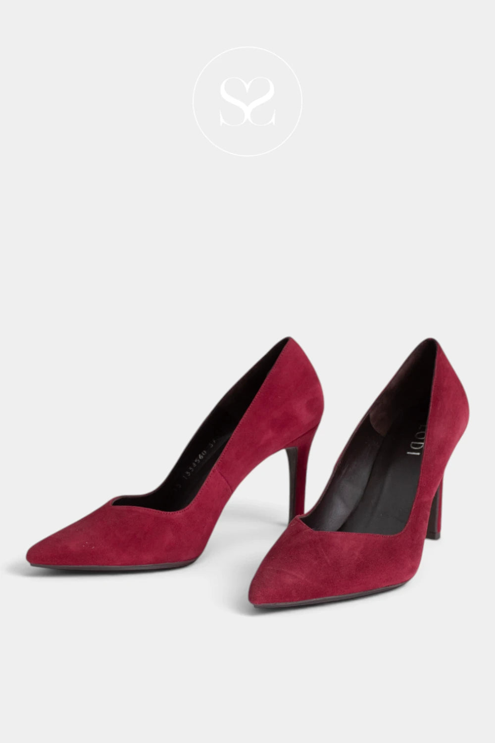 A pair of pointed-toe high heels in deep burgundy suede, displayed on a light grey background with a faint Sheneil Shoes Galway brand logo at the top.