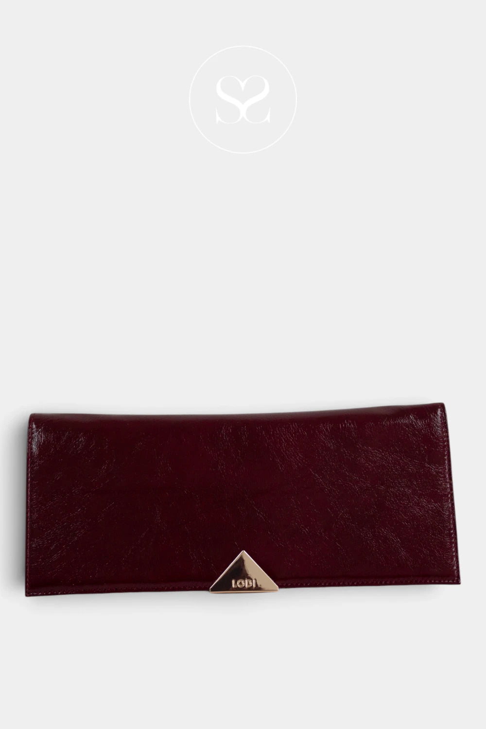 A burgundy leather clutch wallet with a small gold-tone triangular logo clasp on the front from Lodi, displayed against a light grey background. Taken In Galway Ireland