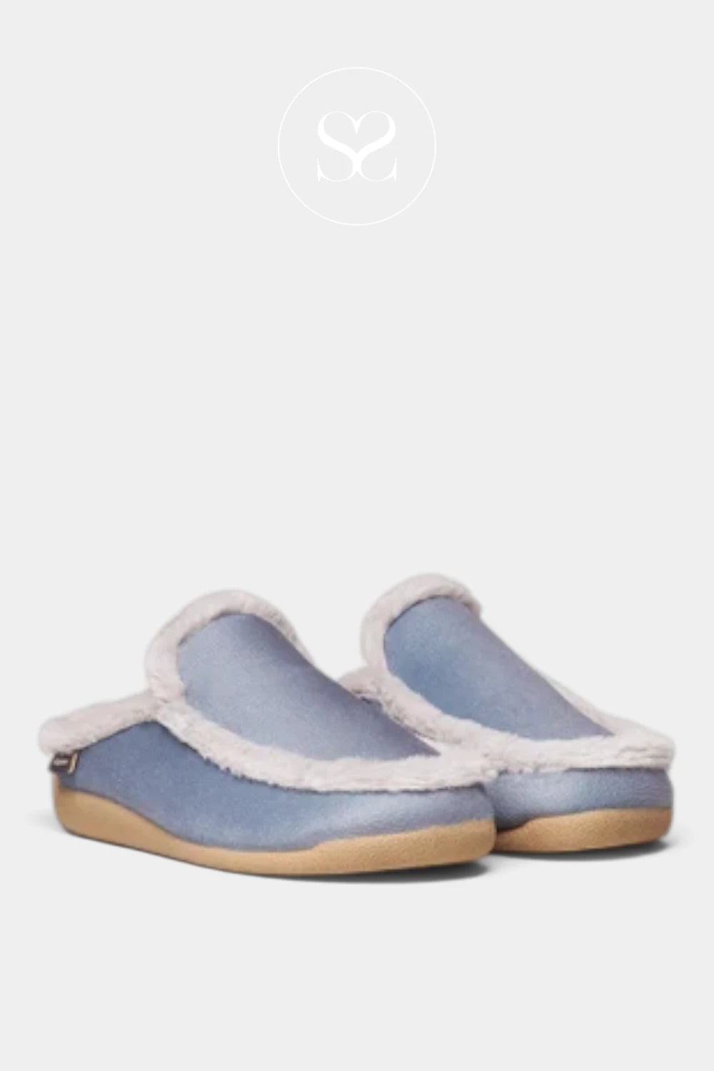 A pair of slip-on slippers in a dusty blue suede-like material with a soft white faux-fur trim and a light tan sole, shown against a light gray background.