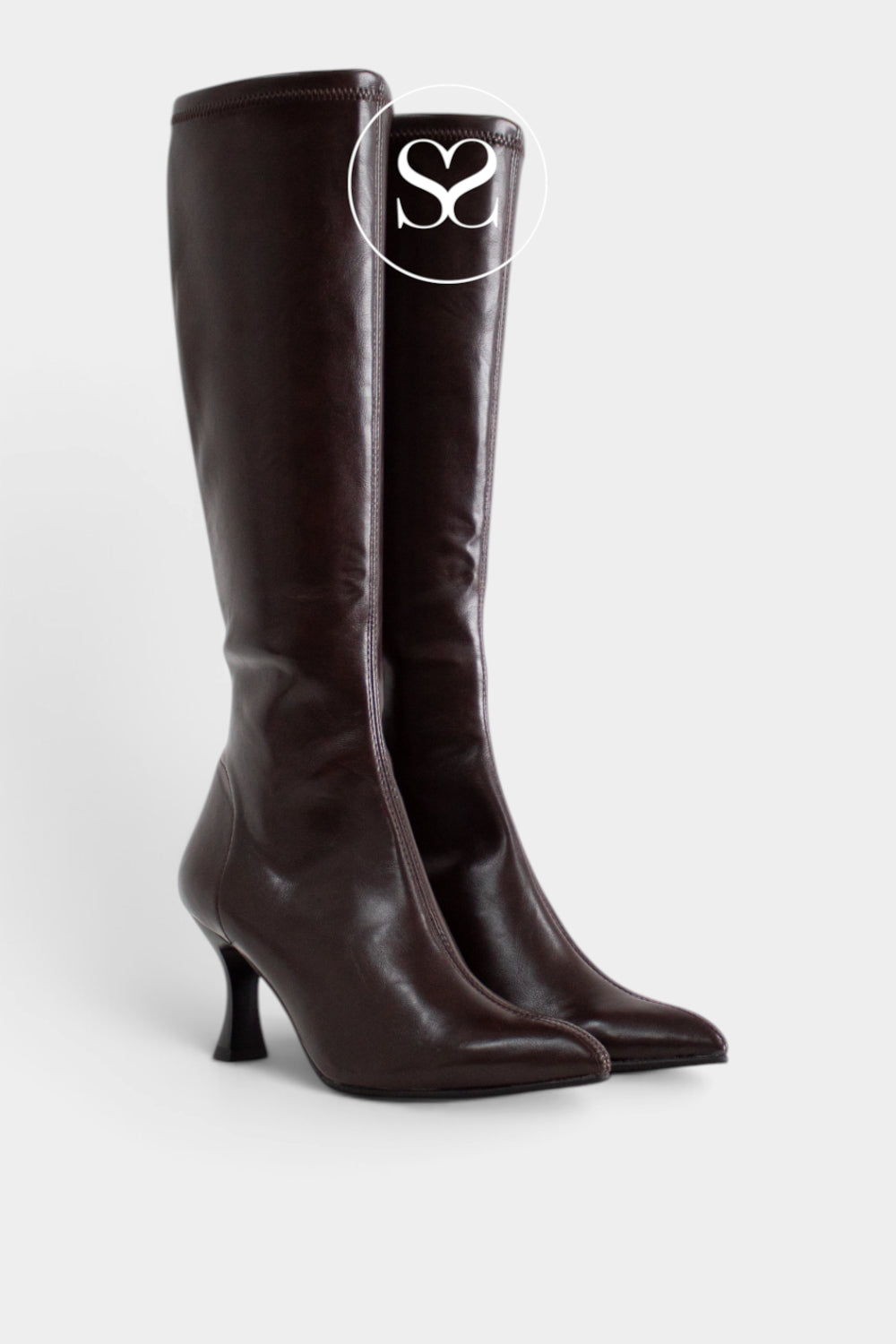 A pair of dark brown leather knee-high boots with pointed toes and kitten heels, shown against a light grey background with a white circular 'Sheneil Shoes' logo overlay near the top.
