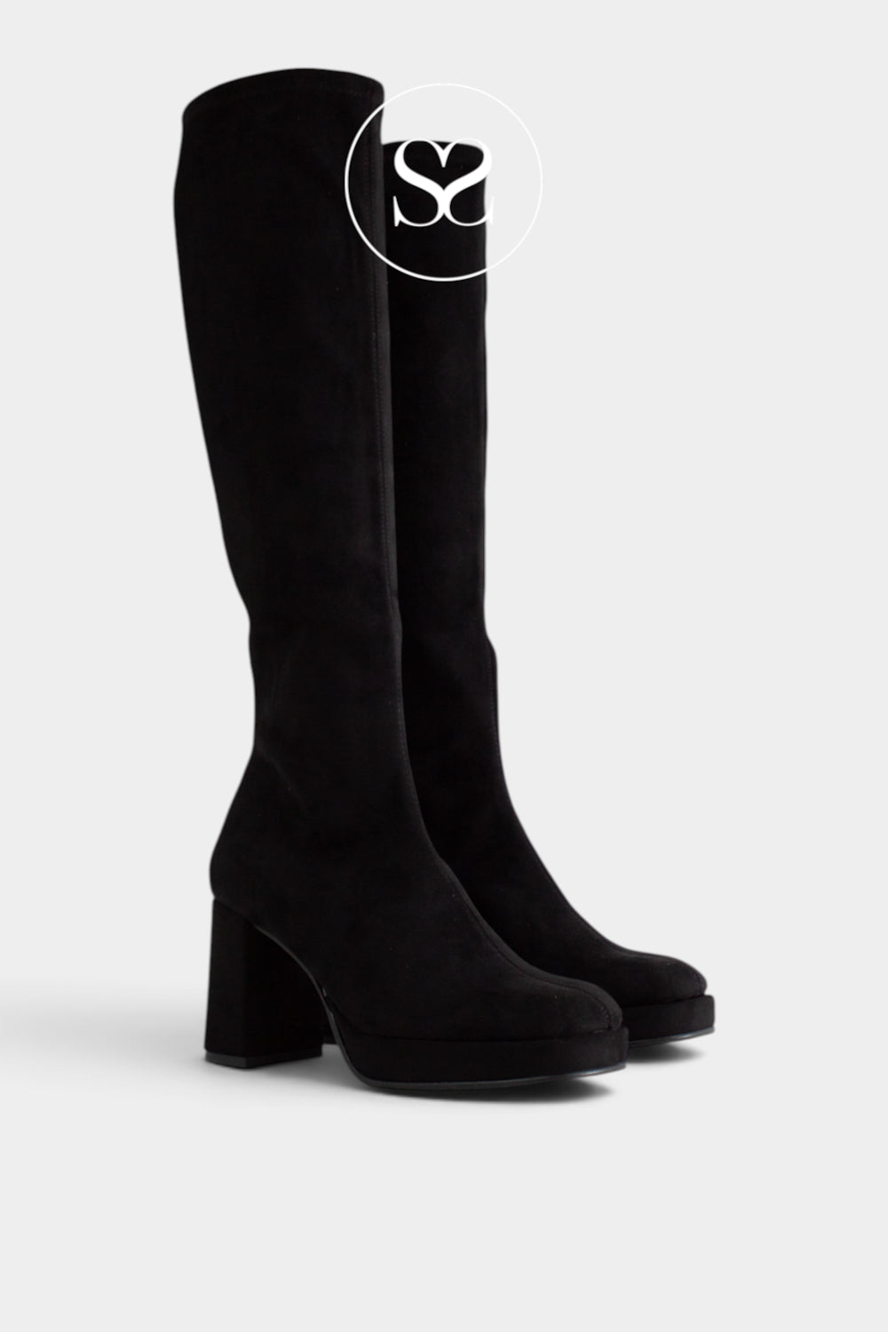 A pair of black suede knee-high boots with chunky block heels and platfrom sole, shown from a three-quarters angle on a light gray background. A circular logo overlay with the letters 'Sheneil Shoes' is visible near the top.