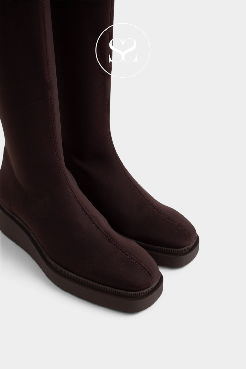 Dark brown Miss Elastic knee-high boots with a matte finish and chunky soles, shown from a side angle on a light grey background.