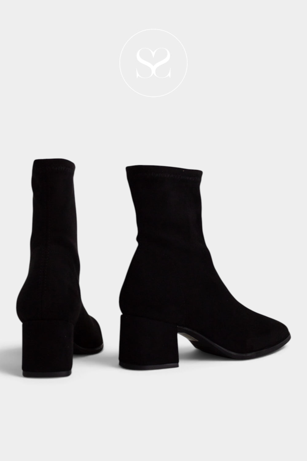 A pair of black suede ankle boots with block heels, shown from the back and side angles on a light gray background.