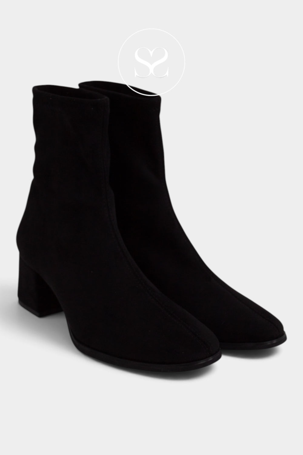 A pair of black suede ankle boots with a block heel and almond toe from Miss Elastic, shown on a light gray background.