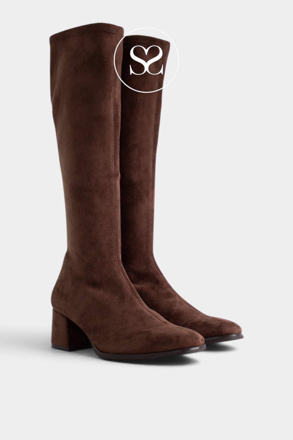 A pair of dark brown suede knee-high boots with a block heel, shown from a three-quarters angle on a light gray background. A white circular logo overlay with the letters 'Sheneil Shoes' is positioned near the top of the right boot.