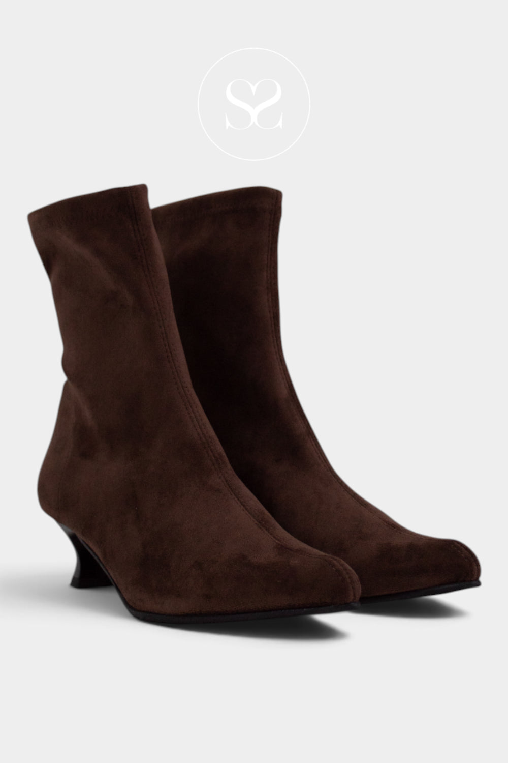 A pair of dark brown suede ankle boots with a low kitten heel, shown from a three-quarters angle on a light grey background.