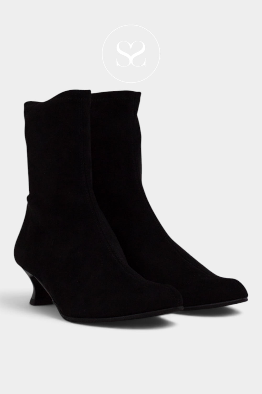 A pair of black suede ankle boots with kitten heels from Miss Elastic shown from a three-quarters angle on a light gray background.