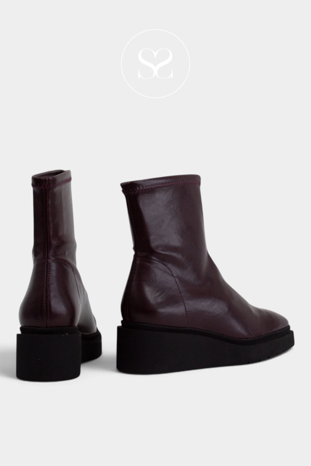 A pair of dark burgundy leather ankle boots with chunky black platform soles, shown from the side and back on a light grey background from Miss Elastic