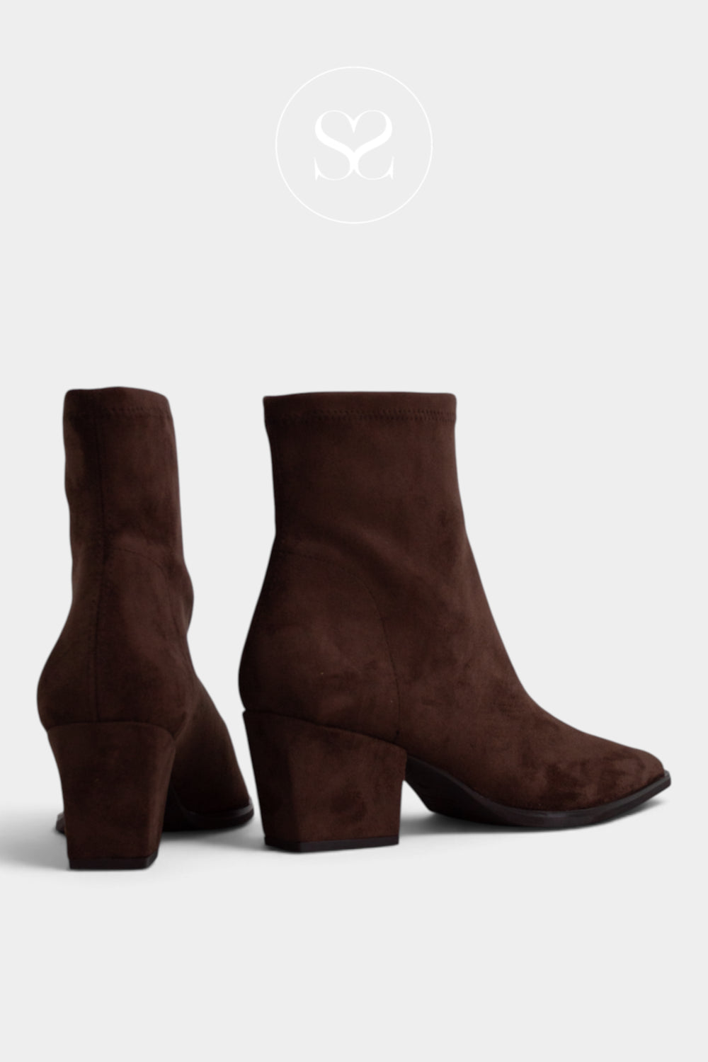 A pair of Miss Elastic dark brown suede ankle boots with block heels, shown from the side and back angles against a light grey background.
