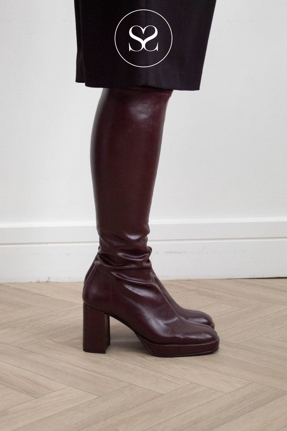 Woman wearing burgundy knee high sock boots with platfrom sole from Miss Elastic in Ireland